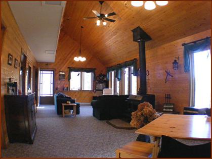 View of the 2-story "Great Room" with vaulted pine ceilings and 9 windows overlooking the lake.