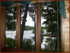 View of lake through the triple floor-to-ceiling windows in the studio area of the Great Room.