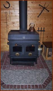 Over-size,  modern, low-clearance, air-tight woodstove with glass doors and alternate open/screened fireplace mode, as well as double-walls and fan for "wood furnace" mode.